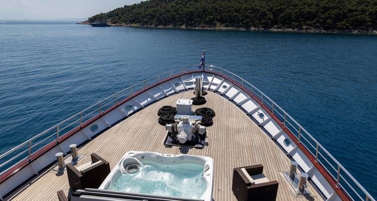 Aussicht vom Schiffsbug mit Teak-Deck, einem kleinen Whirlpool und dem tiefblauen Meer voraus.
