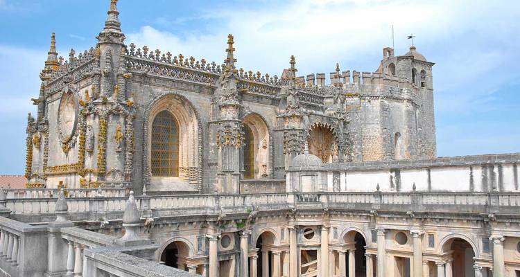 Église gothique-manuelline richement décorée avec des sculptures en pierre ornementales et un cloître en arcade