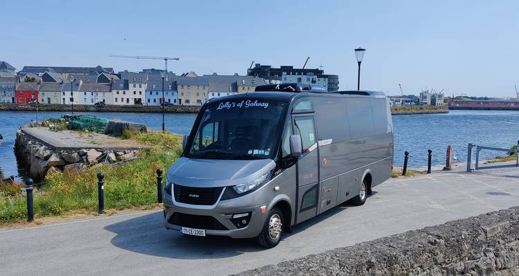 Minibus gris moderne garé à côté des bâtiments colorés du front de mer de Galway.