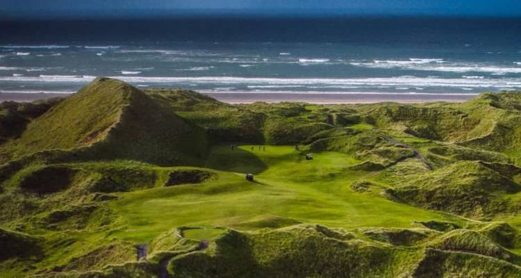 Terrain de golf links sauvage couvert de dunes surplombant une vaste plage de l'Atlantique.