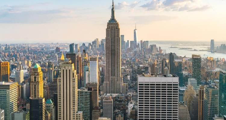 Iconische New York skyline gedomineerd door het Empire State Building in het vage licht van de late middag.
