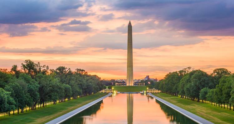Het Washington Monument en de Reflecting Pool gloeien onder een kleurrijke zonsonderganghemel.