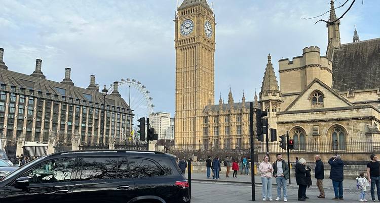 Iconisch uitzicht op Big Ben, Palace of Westminster en het London Eye met toeristen op straat.