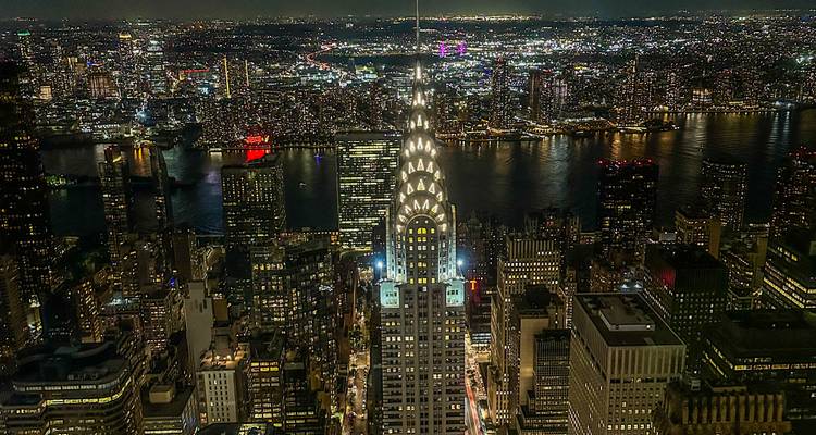 Panorama nocturne de New York avec le Chrysler Building illuminé au-dessus de l'East River.