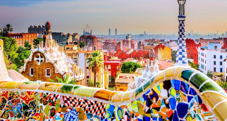 Les terrasses en mosaïque colorées du Parc Güell surplombant la ligne d'horizon de Barcelone à l'heure dorée.