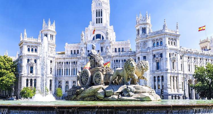 La fontaine ornée de Cibeles avec le grand Palacio de Cibeles à l'arrière-plan sous un ciel bleu dégagé.