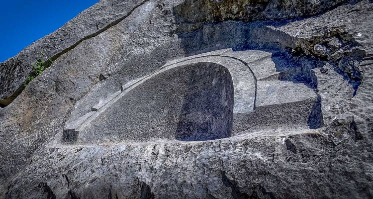 Dicht erbij een fijn uitgehouwen stenen nis in een enorme grijze rots op een Andes-locatie.
