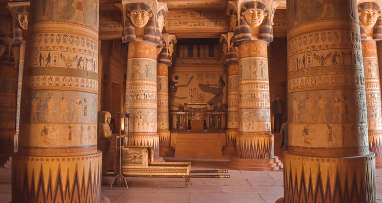 Interior hall with richly painted columns and hieroglyphic motifs reminiscent of an ancient Egyptian set or museum exhibit.