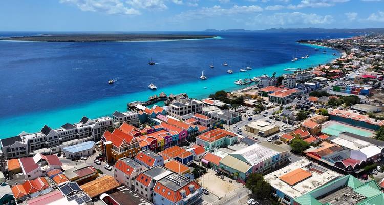 Paysage urbain coloré de Kralendijk en bord de mer avec des toits aux couleurs vives à côté d'une eau turquoise éclatante vue d'en haut.