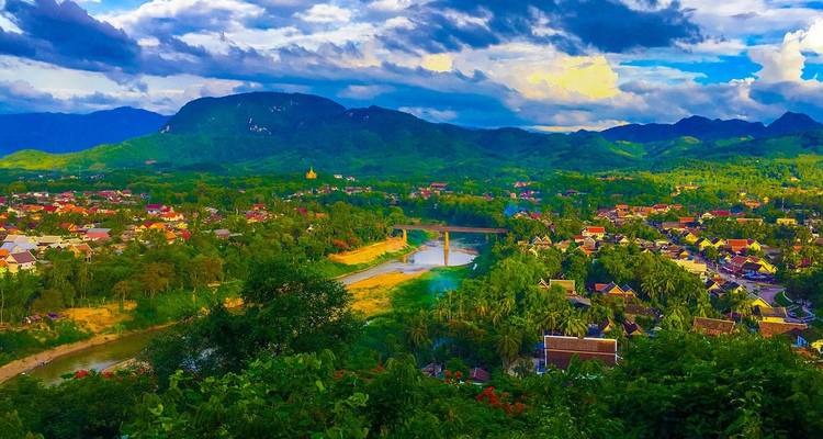 Levendig panoramisch uitzicht over Luang Prabang met rivier, brug en mistige bergen