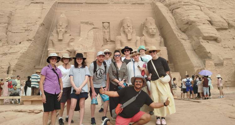 Toeristengroep die lacht voor de gigantische standbeelden van Abu Simbels hoofdtempel