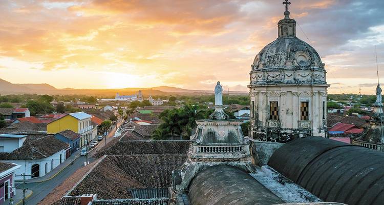 Coucher de soleil doré sur les toits coloniaux et les dômes de la cathédrale de Grenade, au Nicaragua.