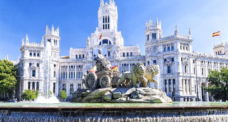 La grande Fontaine de Cibèles avec le Palacio de Cibeles derrière elle sous un ciel bleu clair à Madrid.