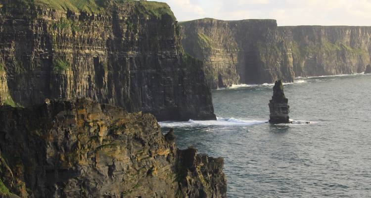Les falaises spectaculaires du Cliffs of Moher qui plongent abruptement dans l'océan Atlantique avec des vagues s'écrasant en contrebas.