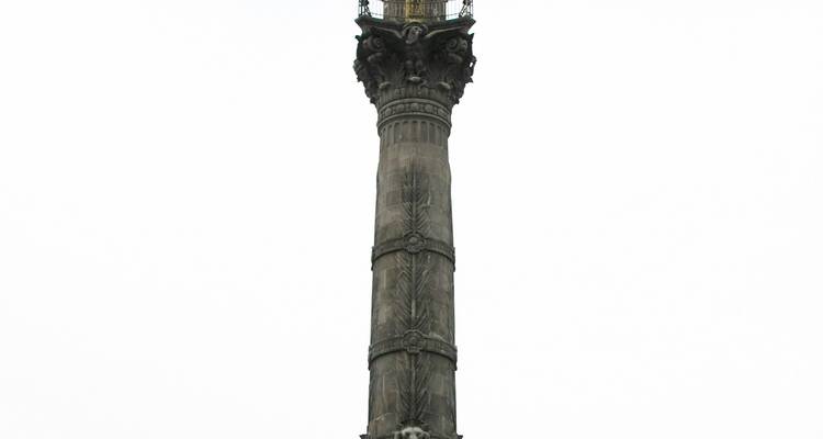 Grande colonne de pierre de l'Ange de l'Indépendance isolée sur un ciel blanc vierge.