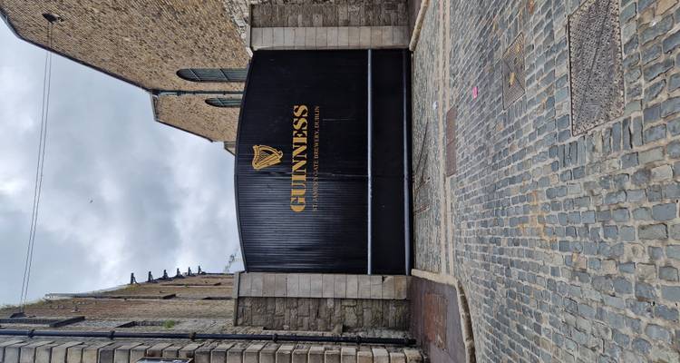 Portes en fer forgé noir de la brasserie Guinness Storehouse sur une rue pavée avec des bâtiments en pierre de chaque côté