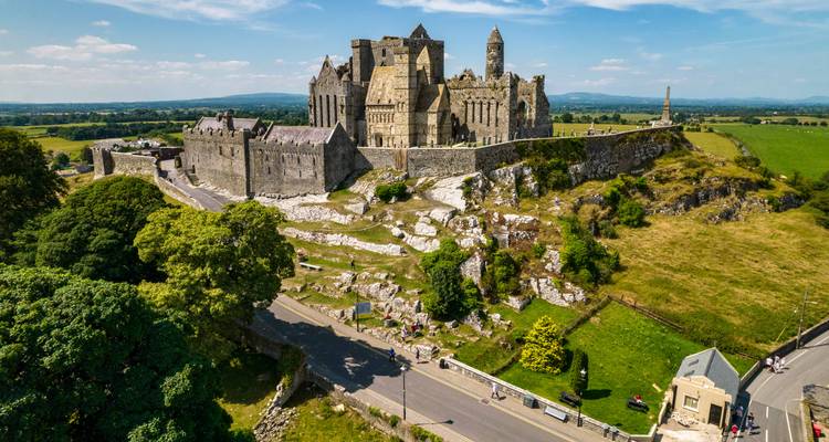 Vue aérienne du complexe castral du Rocher de Cashel au sommet d'un affleurement calcaire entouré de la campagne irlandaise sous un ciel bleu
