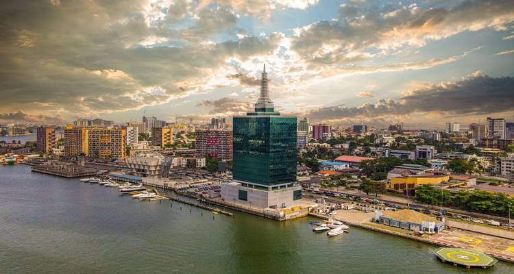 Vista aérea espectacular del horizonte de Lagos Island con una laguna brillante y torres modernas reflejando las nubes del atardecer.