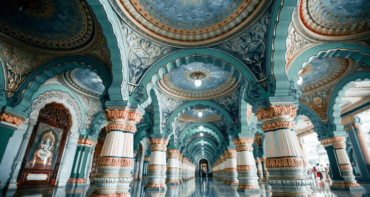 Grand hall orné aux piliers imposants du Palais de Mysore, décorée d'arcs en bleu-vert et or, avec un sol en marbre brillant.