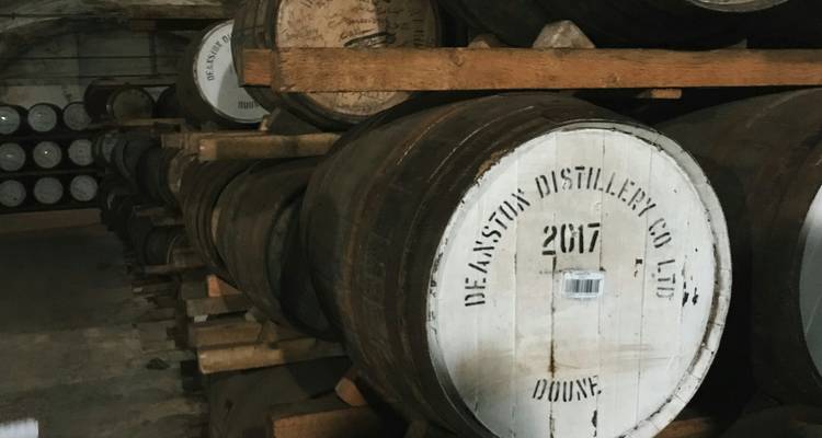 Des rangées de fûts de chêne contenant du whisky vieillissant à l'intérieur de l'entrepôt de la distillerie Deanston.