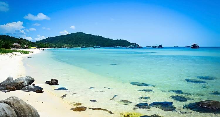 Crystal-clear turquoise water and white sand beach with gentle waves on Phu Quoc Island