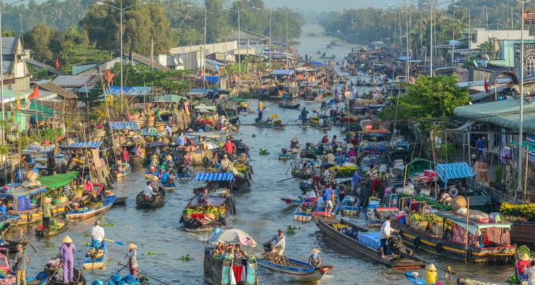Crowded floating market on a Mekong Delta canal packed with produce-laden boats.