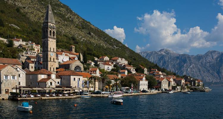Malerisches Hafendorf mit Steinhäusern und Kirchturm an der Bucht von Kotor
