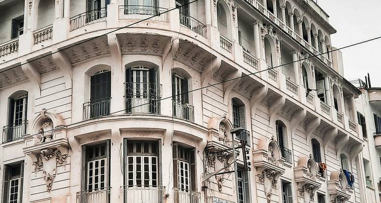 Elegante Fassade im französischen Stil eines historischen Stadtgebäudes mit schmiedeeisernen Balkonen.
