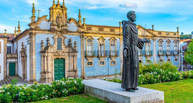 Statue d'un saint devant la façade ornée du Palacio do Raio aux carreaux bleus dans le centre historique de Braga.