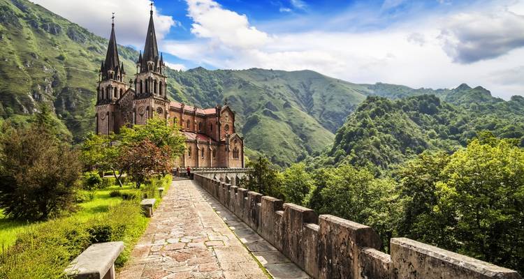 Neoromantische Basilika von Covadonga vor üppig grünen Bergen und Tal.