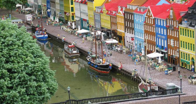 Maquette miniature du Nyhavn de Copenhague recréée avec des bâtiments LEGO colorés et des bateaux jouets à côté d'un minuscule canal.