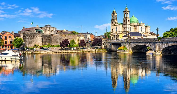 La cathédrale et le château au bord de la rivière d'Athlone se reflétant dans l'eau bleue et calme d'une matinée ensoleillée.