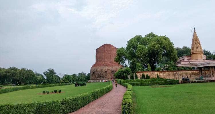 Pathway leads to the massive Dhamek Stupa surrounded by manicured lawns in Sarnath.