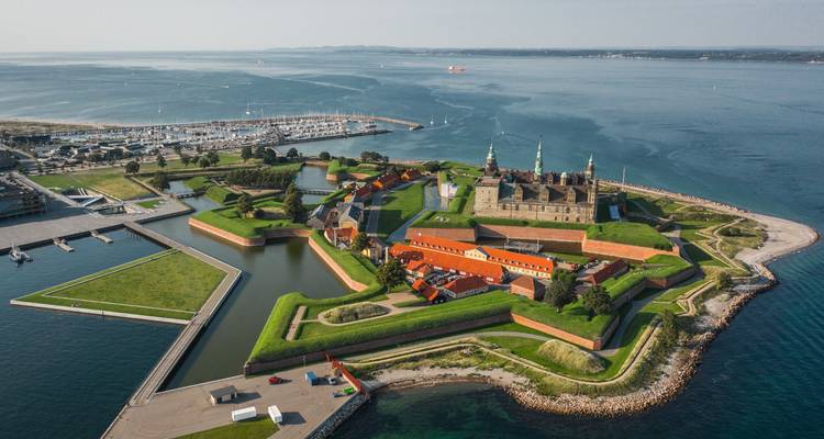 Vista aérea de las murallas en forma de estrella y los céspedes verdes del Castillo de Kronborg que se asoman en las tranquilas aguas azules.