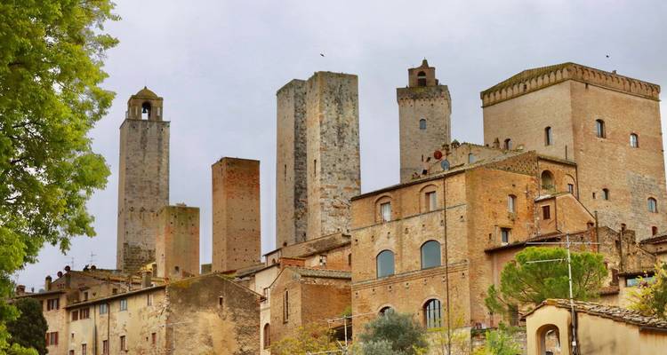 Des tours médiévales en brique s'élèvent au-dessus de l'horizon de la ville de San Gimignano perchée sur une colline.