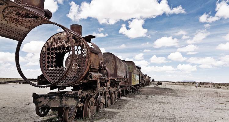 Los restos oxidados de locomotoras se alinean en el terreno árido del Cementerio de Trenes de Uyuni.