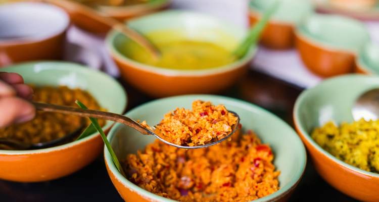 Close-up van Sri Lankaanse curry garnituren die uit felgekleurde kommen worden geserveerd