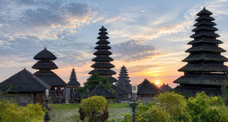 Les silhouettes des toits de pagode à plusieurs étages du temple de Besakih sur un ciel d'aube coloré.