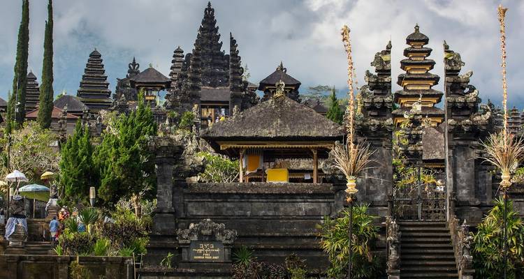 Entrée du complexe du temple Besakih avec des portes en pierre ornementales et la brume des montagnes.