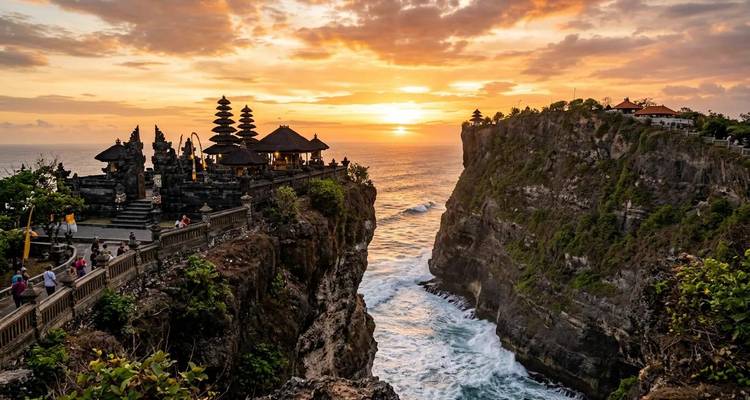 Scène de coucher de soleil au temple d'Uluwatu avec des falaises spectaculaires et un horizon lumineux.