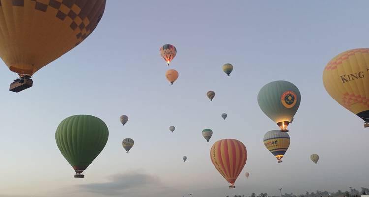 Dutzende farbenfroher Heißluftballons, die über dem Morgenhimmel von Luxor schweben.
