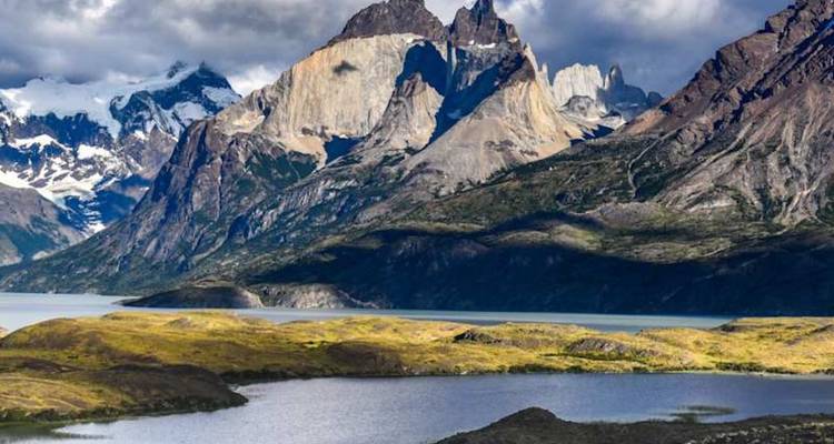 La luz del sol y las sombras juegan entre los picos escarpados y un lago sinuoso en Torres del Paine.