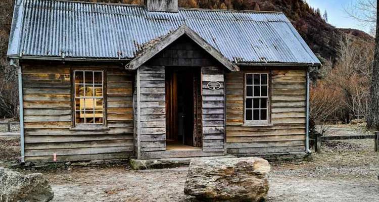 Petite chaumière rustique en bois de mineur avec toit en tôle ondulée dans un établissement historique.