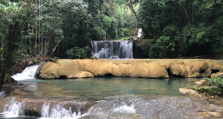 Cascade de jungle multi-étages s'écoulant dans un bassin cristallin entouré de forêt tropicale