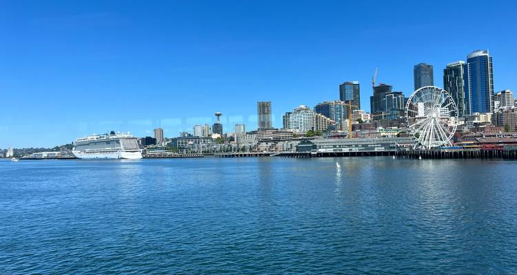 Vue ensoleillée et brillante de l'horizon de Seattle, d'un navire de croisière et de la Grande Roue depuis l'eau.