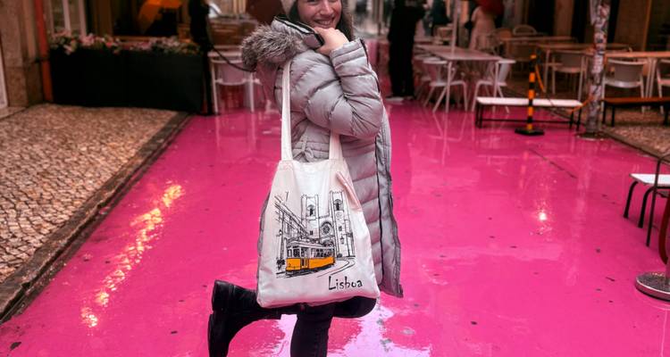 Fashionable woman playfully posing on Lisbon’s vibrant Pink Street after the rain