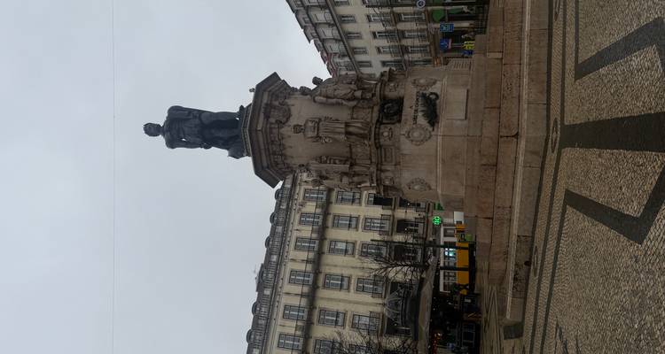 Statue of Luís de Camões on a pedestal in a quiet Lisbon square framed by historic buildings