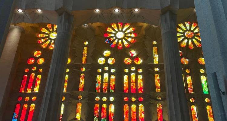 Des vitraux en verre teinté d'un rouge éclatant et d'un jaune vif à l'intérieur de la Sagrada Familia illuminés par la lumière du soleil