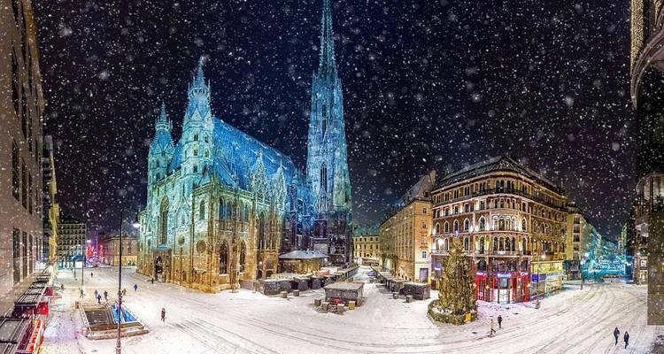 La Cathédrale Saint-Étienne et la place environnante recouvertes de neige fraîche lors d'une nuit d'hiver scintillante.