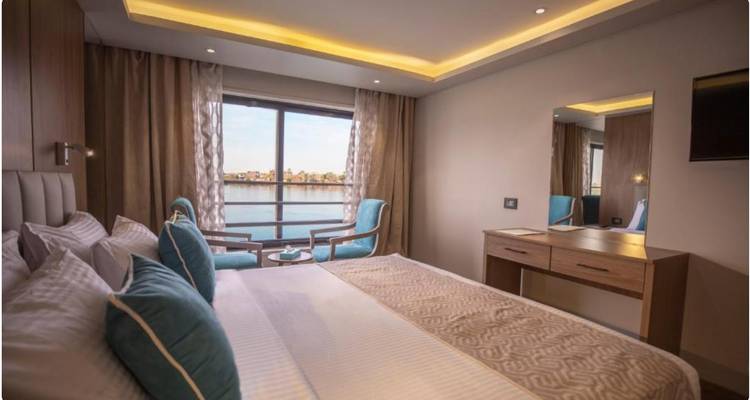 Une cabine de bateau de croisière élégante avec de grandes vues sur le fleuve et une décoration contemporaine.